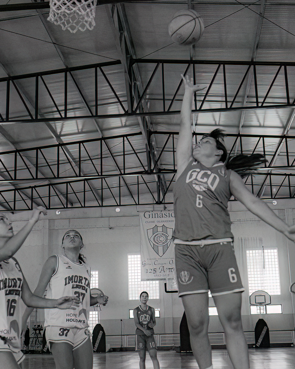 Basketball player in action during a game in a gymnasium.
