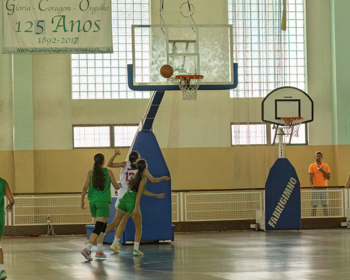 Basketball game in progress with players on a court, featuring a banner celebrating a 125th anniversary.