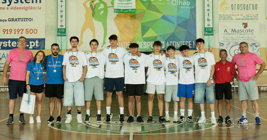 Group of young men and women standing on a basketball court, wearing sports jerseys and shorts.