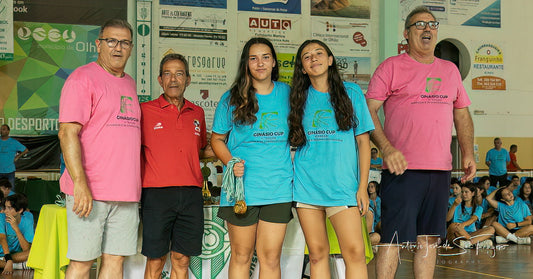 Group of people on a sports court with banners and spectators in the background