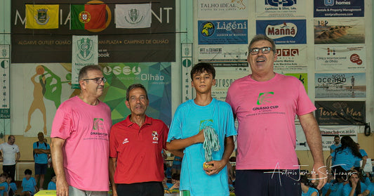 Group of people standing together with a person holding an award in a sports arena setting.