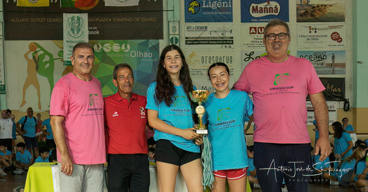 Group of people, including children and adults, posing with a trophy in an indoor setting.
