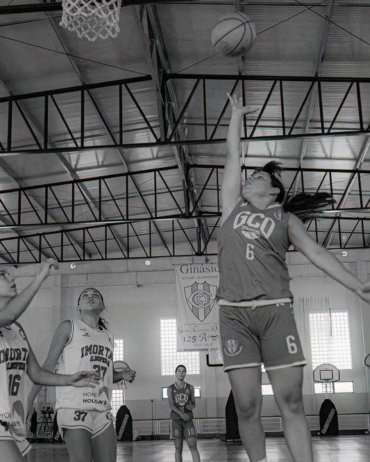 Basketball player in action during a game in a gymnasium.