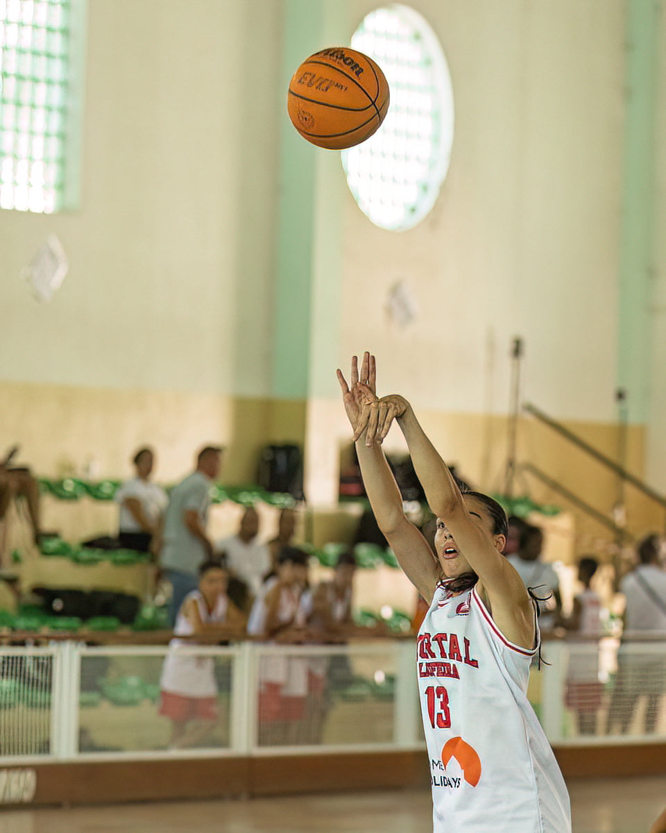Basketball player in action during a game in an indoor sports facility.