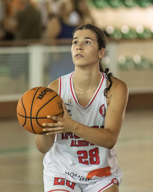 Basketball player holding a ball on a court with a blurred background