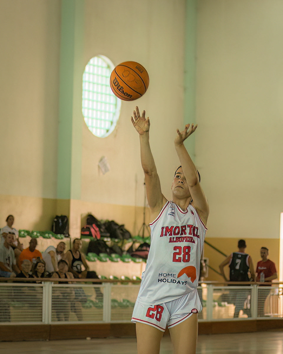 Basketball player in action during a game, with a Wilson basketball.