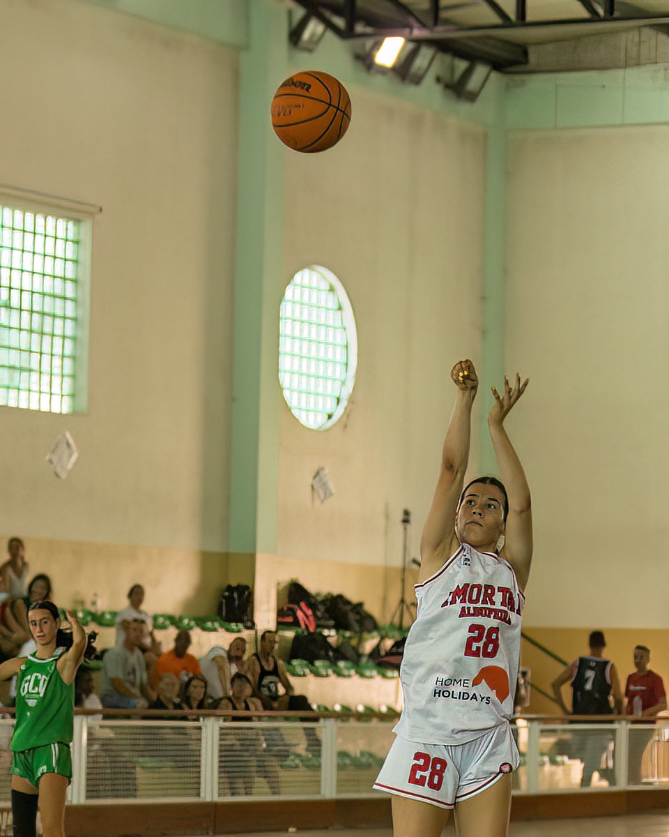 Basketball player in action during a game with a crowd watching.