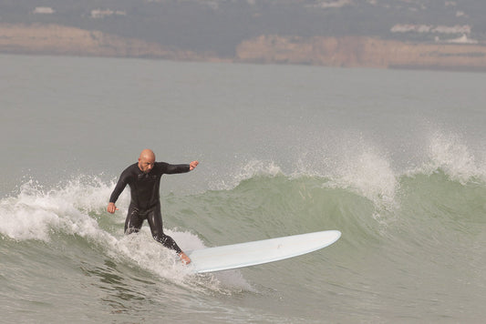 Person surfing on a wave in a wetsuit with a blurred background